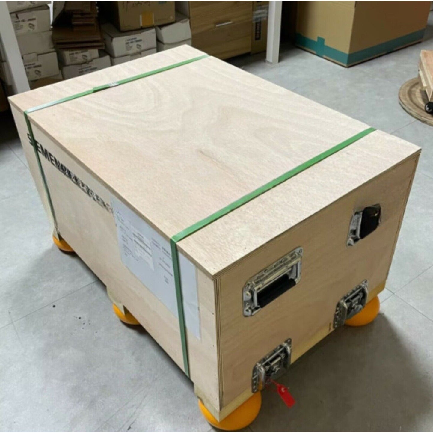 Siemens PLC Power Block shipping crate. Wooden box with green straps, metal hardware, and orange wheels.