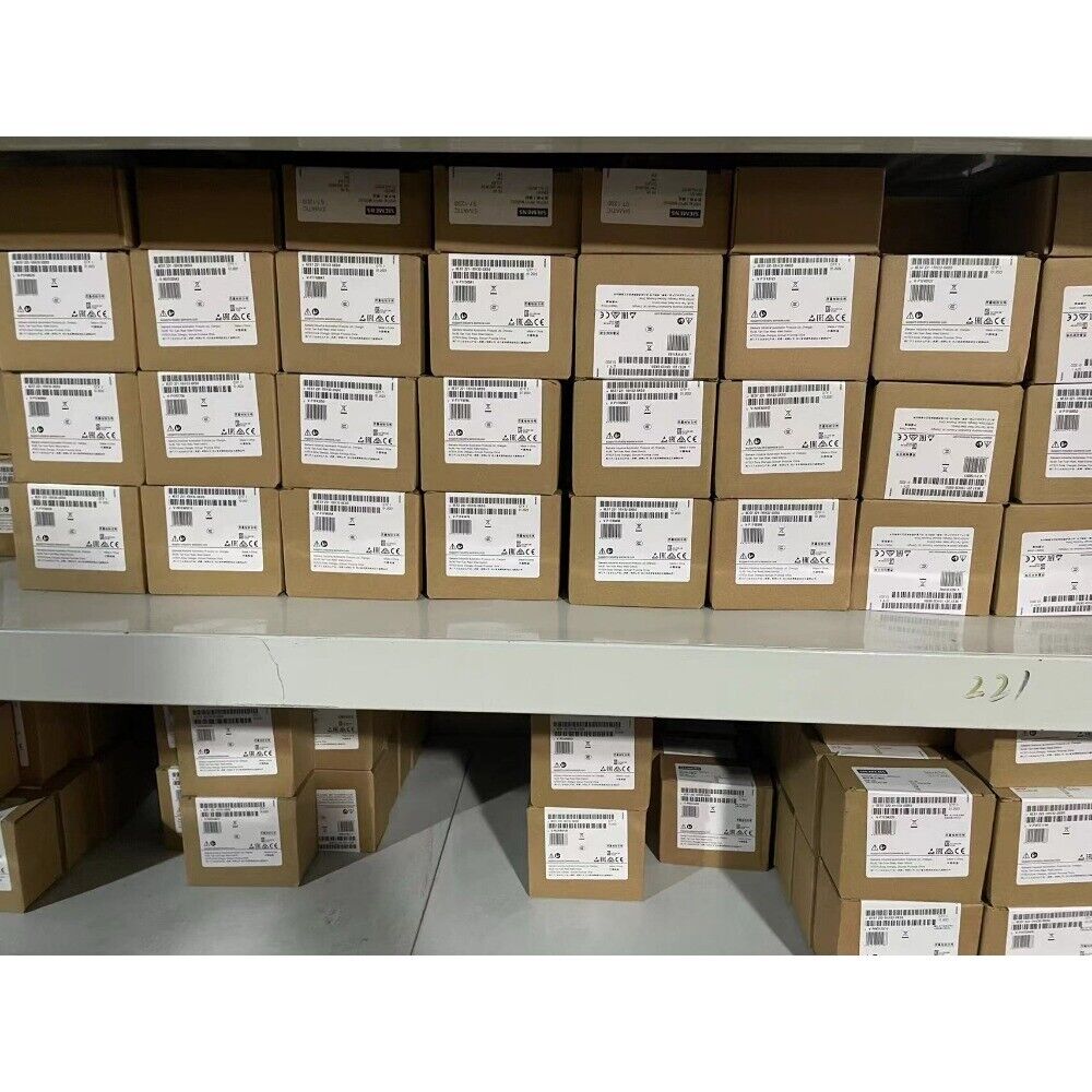 Stack of new Mitsubishi Q38DB PLC base unit boxes in industrial warehouse, barcode labels visible, ready for shipping.