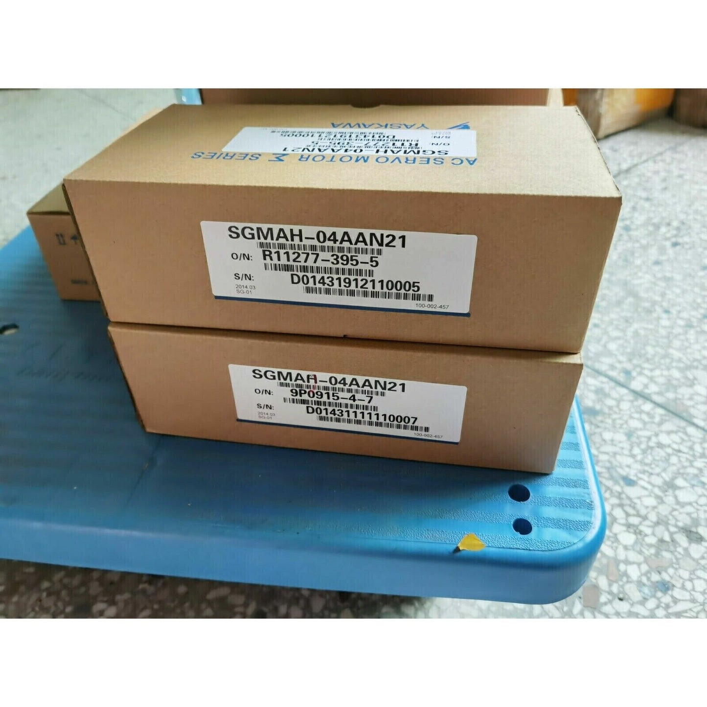 Yaskawa SGMAH-04AAN21 AC Servo Motor boxes on a blue surface, new industrial automation parts