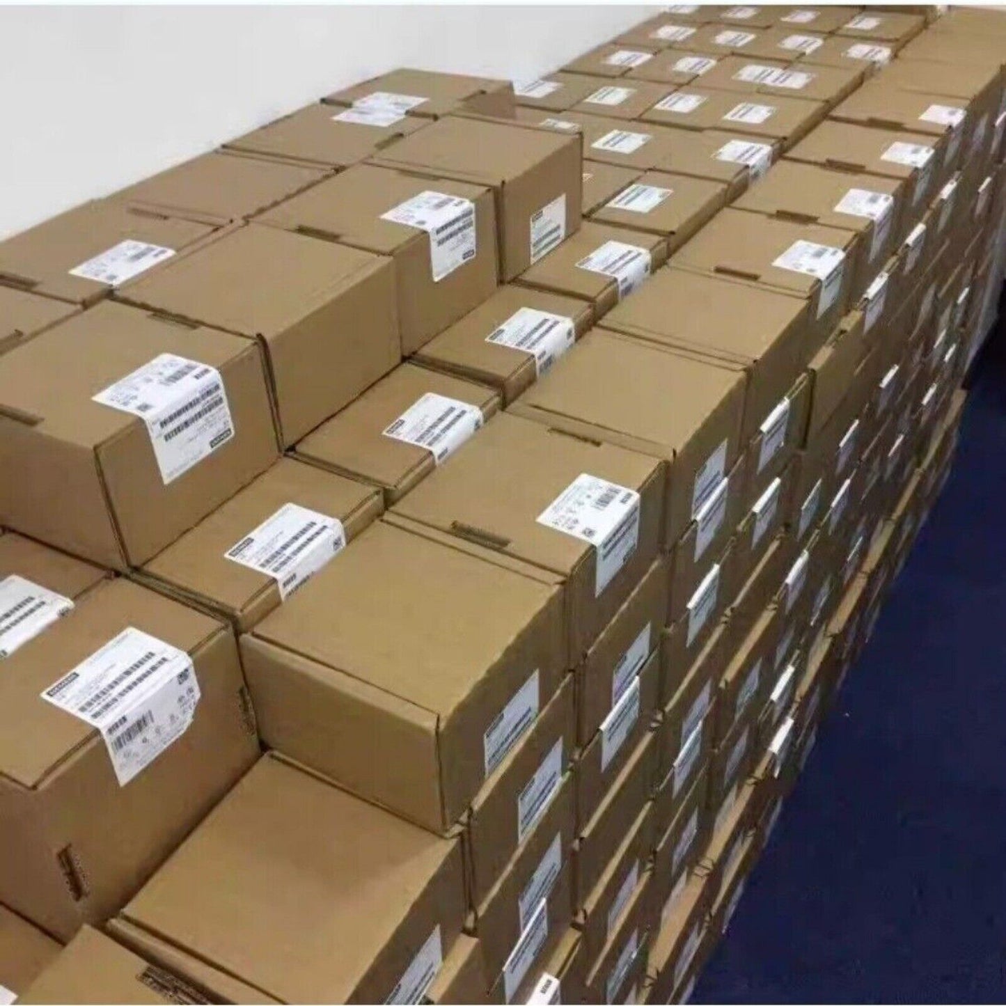 Stacked boxes of SIMATIC S7-300 PLC modules ready for shipment, industrial automation parts.