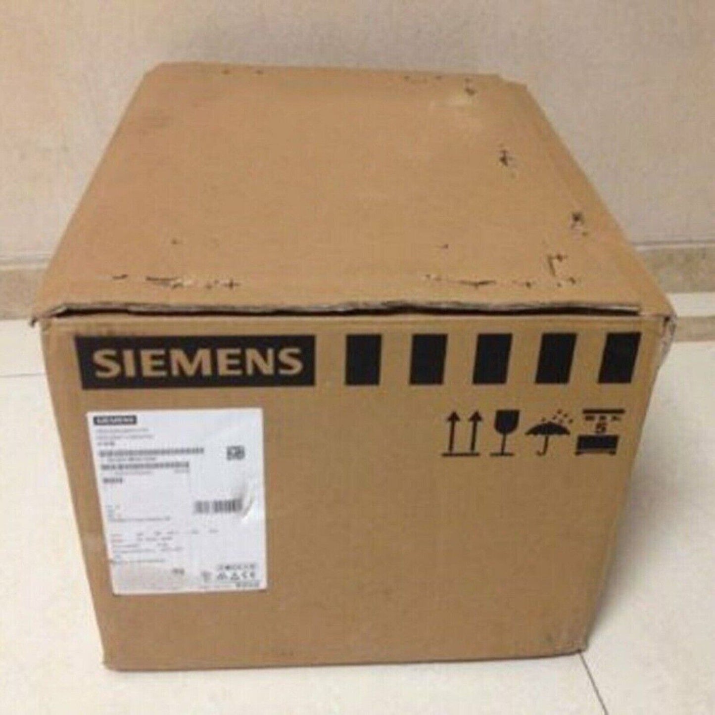 Siemens industrial automation part packaging box, with shipping labels, Siemens logo, and fragile symbols.
