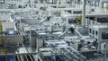 A wide shot of a modern factory with multiple robotic arms working on an assembly line.