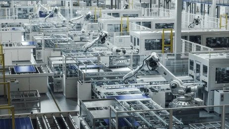 A wide shot of a modern factory with multiple robotic arms working on an assembly line.