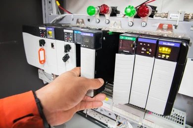 A technician installing a programmable logic controller (PLC) module.