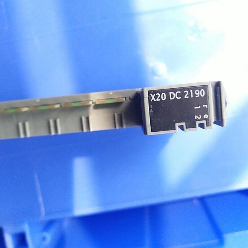 B&R X20 DC 2190 controller module. Gray and black electronic component on a blue background.