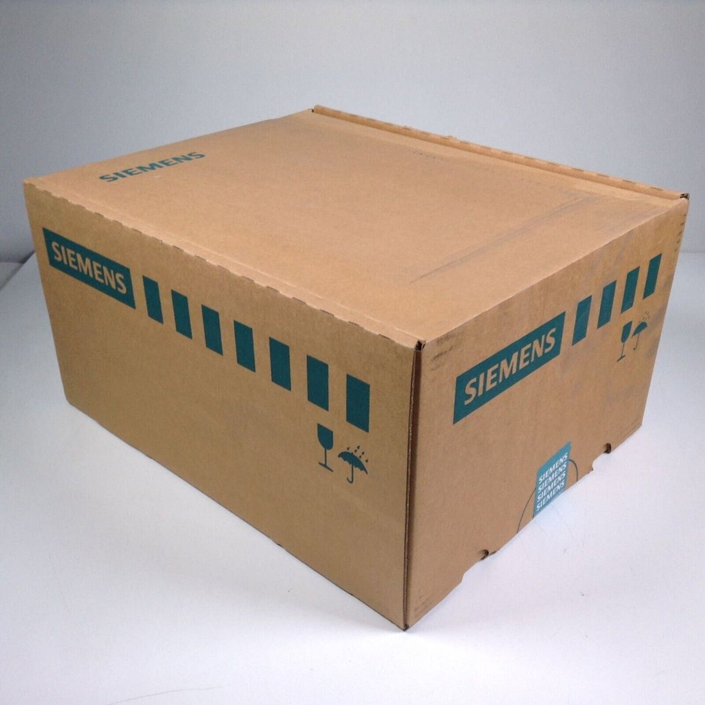 Siemens industrial automation part packaging box, brown cardboard with green text, product shipping container.