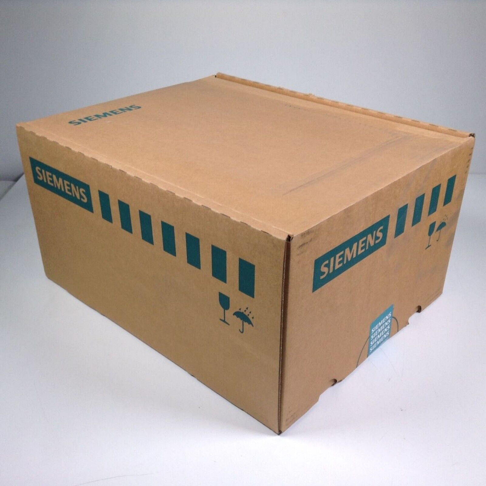Siemens industrial automation part packaging box, brown cardboard with green text, product shipping container.