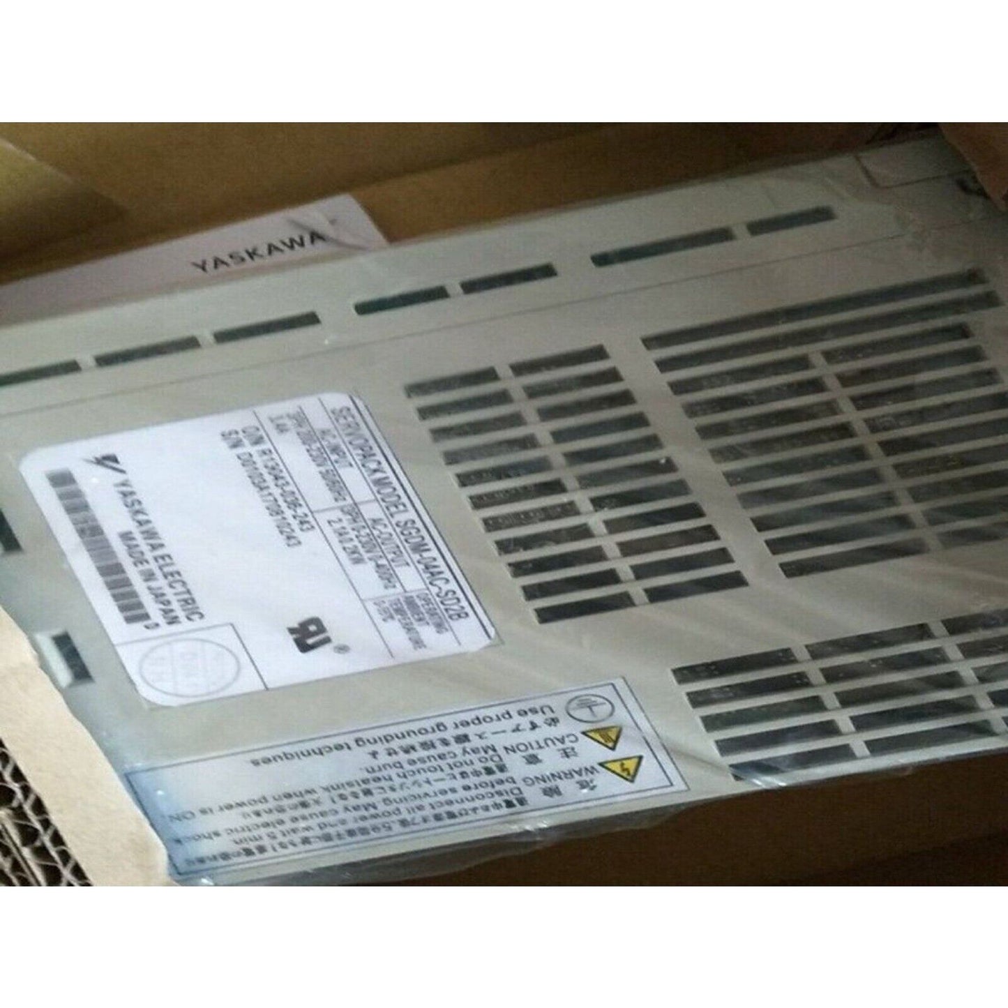 YASKAWA SGDM-04AC-SD2B Servo Drive, NEW, made in Japan. Features product label details and warning labels.