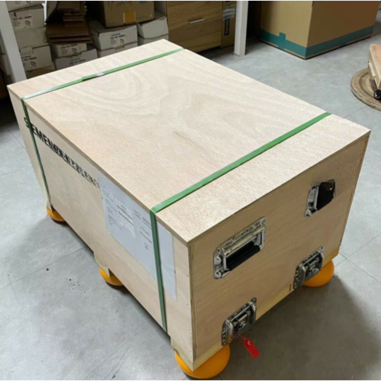 Siemens PLC Power Block shipping crate. Wooden box with green straps, metal hardware, and orange wheels.