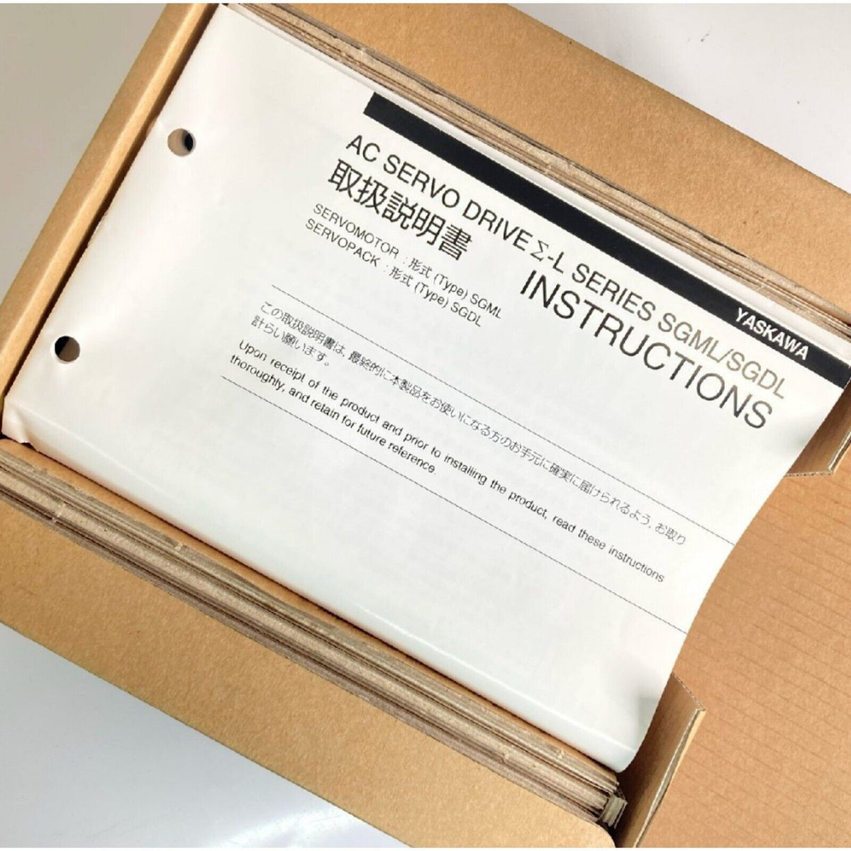 Yaskawa AC Servo Drive instructions in box. SGML/SGDL series documentation. New industrial automation parts.