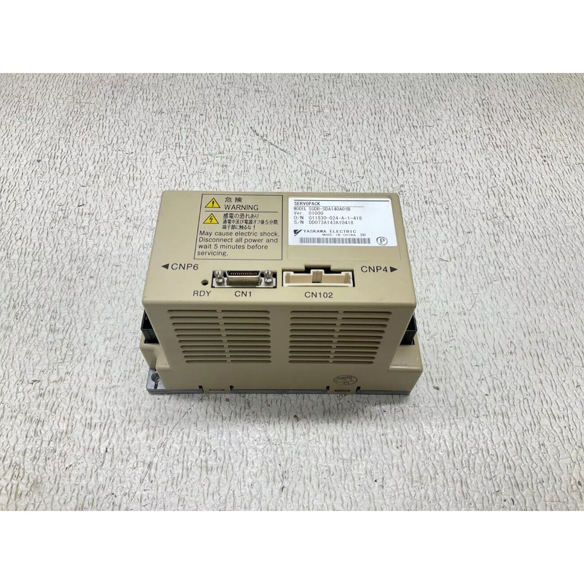 Yaskawa SGDR-SDA140A01B servo drive. Electrical warning label visible on the industrial automation component.