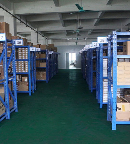Warehouse interior with blue shelves of Schneider Electric industrial automation parts, ready to ship.