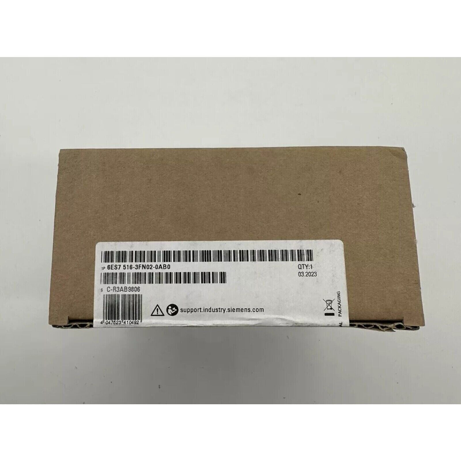 Siemens S7-1500 PLC in cardboard box, 6ES7 516-3FN02-0AB0, with product label and support website address.