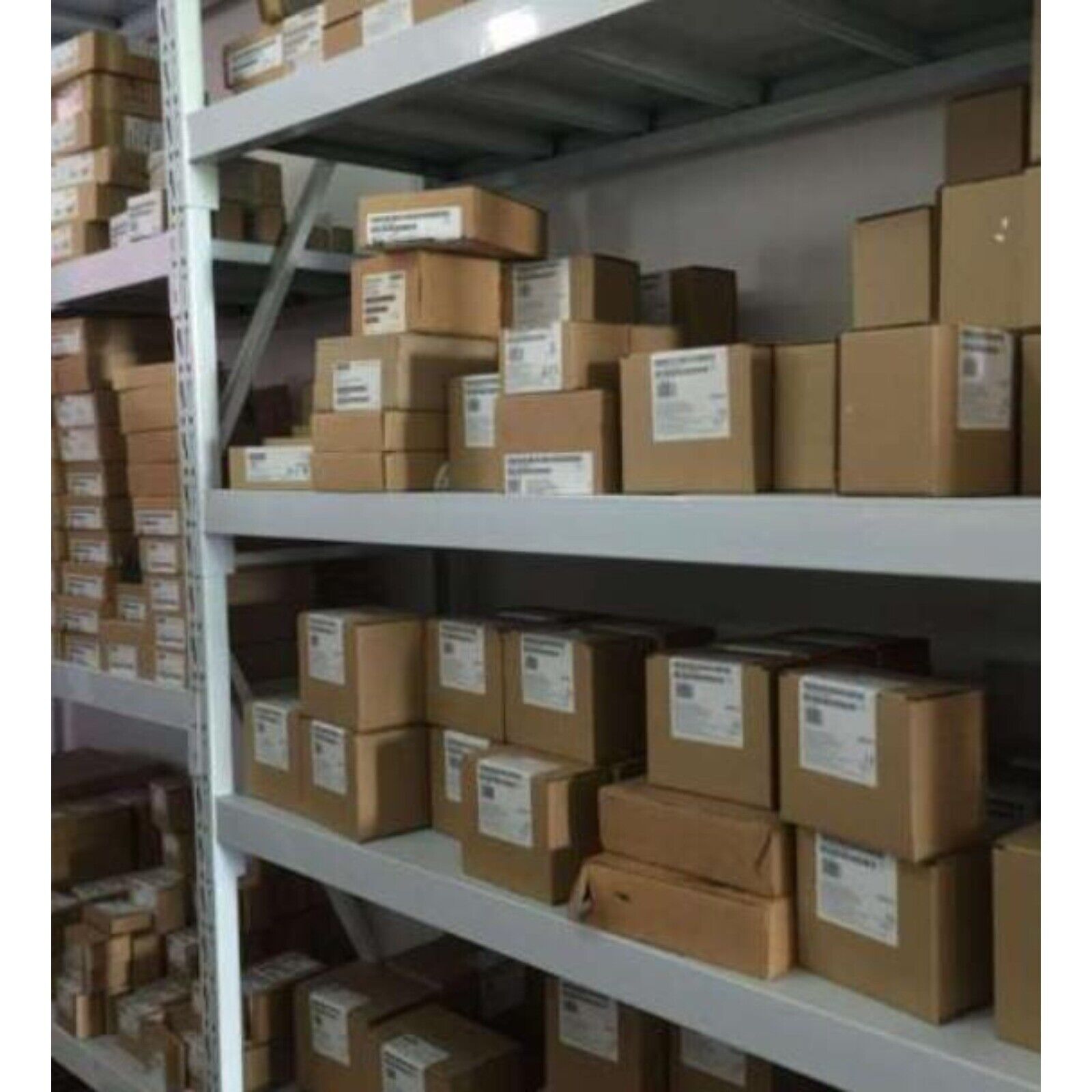 Warehouse shelves stocked with Siemens industrial automation components in boxes, ready for fast shipping.