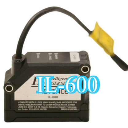 Keyence IL-600 laser sensor, black body with cable and yellow tip, industrial automation part.
