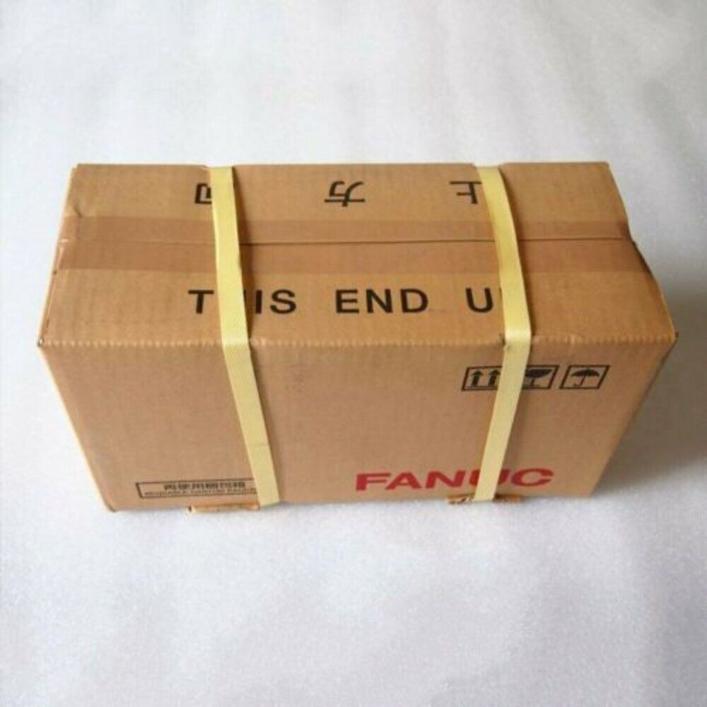 FANUC servo motor packaged in a brown cardboard box, labeled 'THIS END UP'.