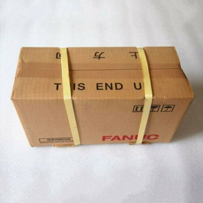 FANUC servo motor packaged in a brown cardboard box, labeled 'THIS END UP'.