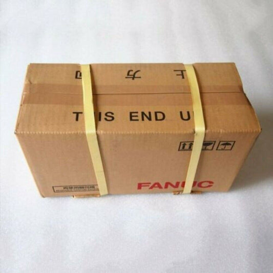 FANUC servo motor packaged in a brown cardboard box, labeled 'THIS END UP'.