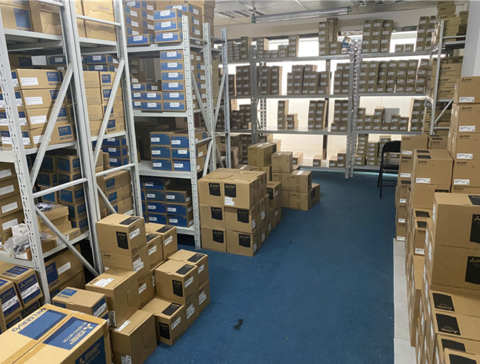 Warehouse of Mitsubishi MR-J2S-40A-S004 servo drives in boxes, industrial automation parts.