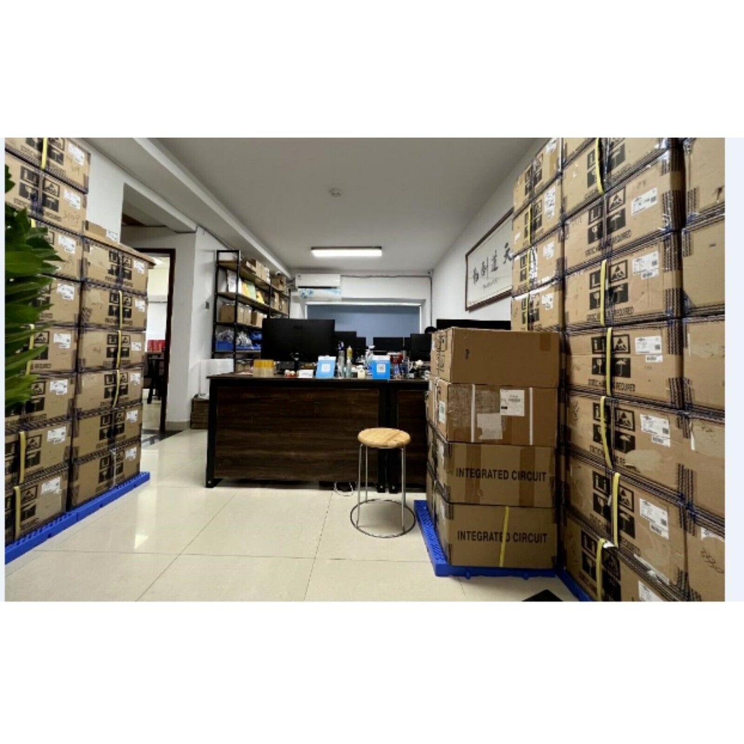 Warehouse interior with stacked boxes of integrated circuit products, industrial automation components.