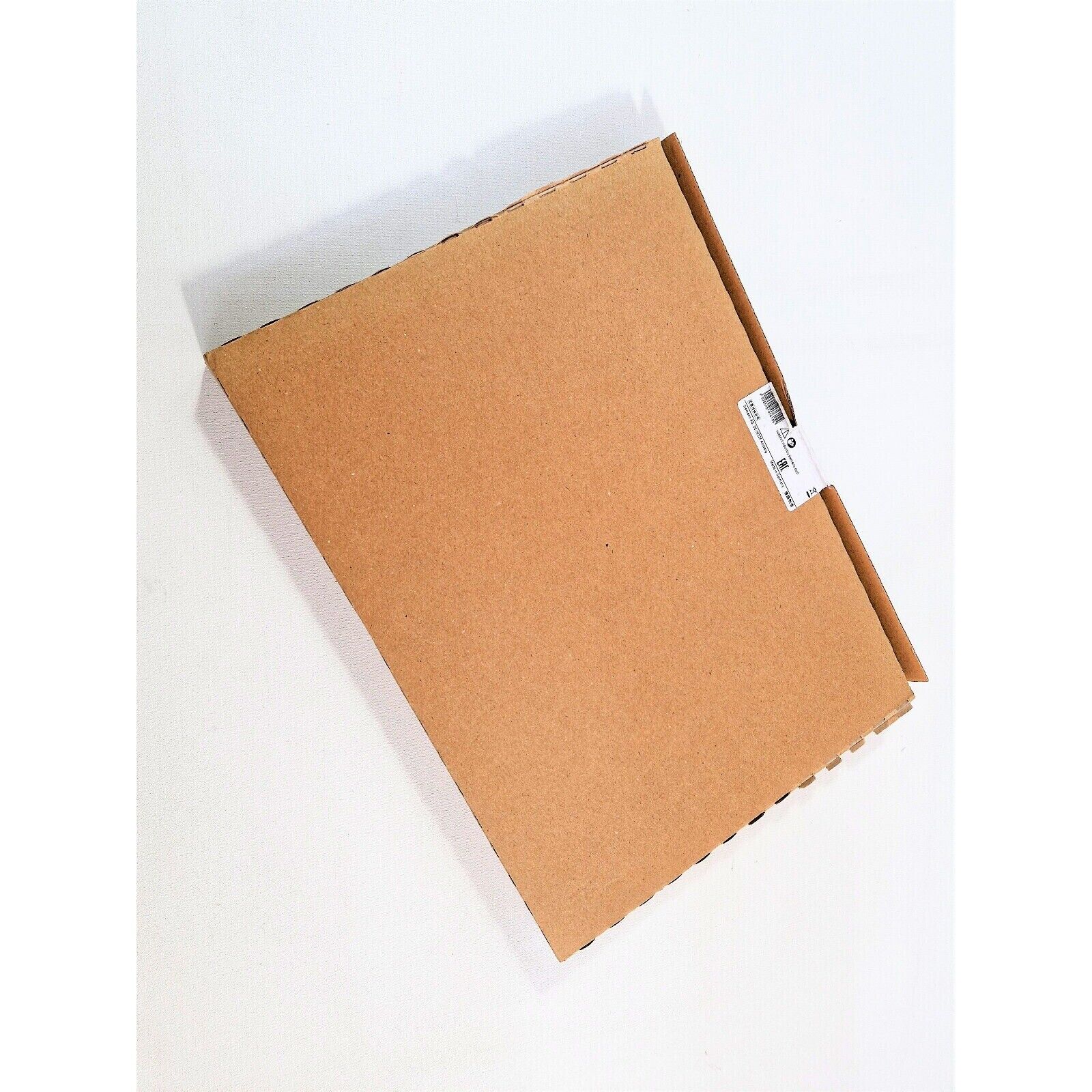 Brown cardboard box packaging for Siemens PLC module, angled view on a white surface.