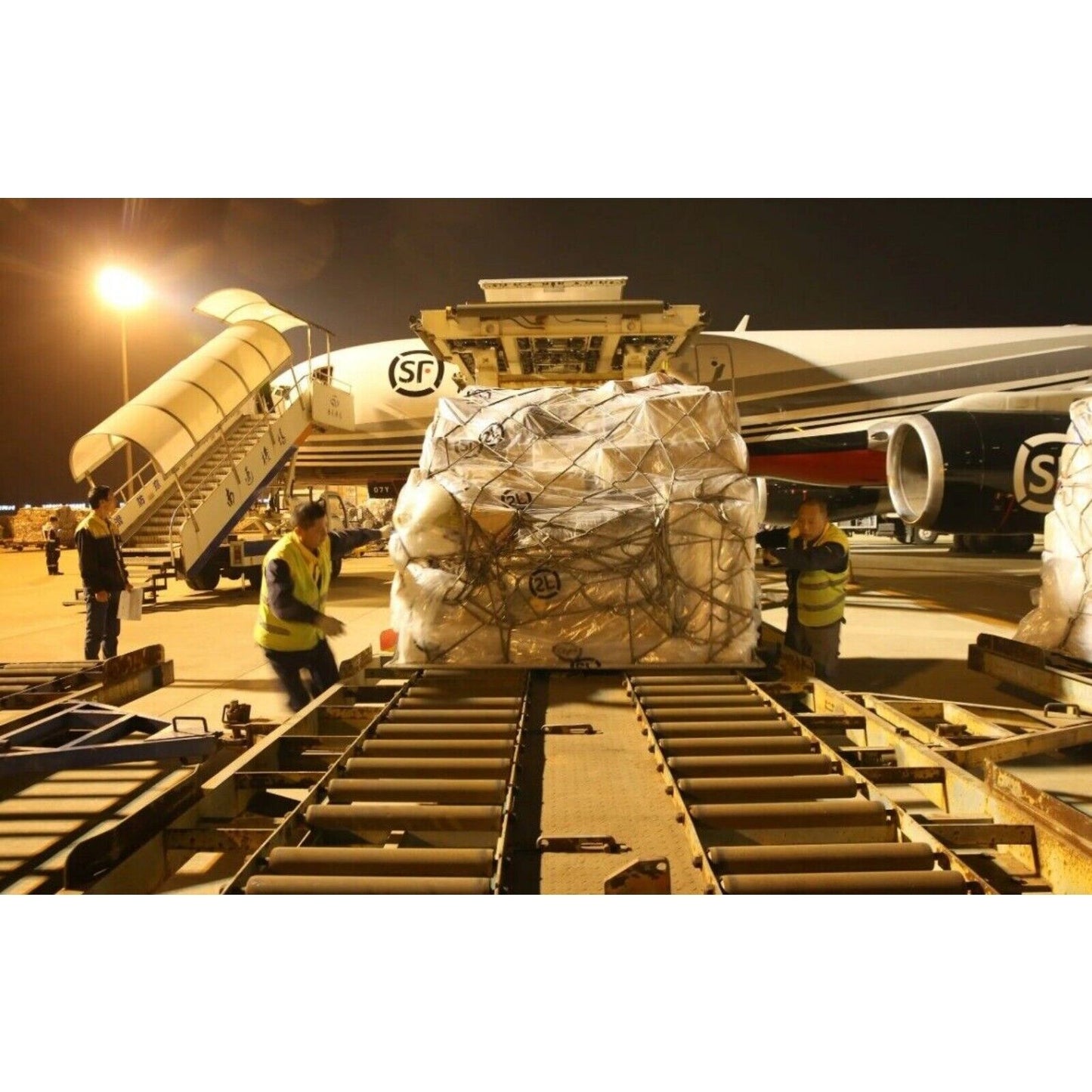 Industrial automation parts air cargo loading at night with SF Airlines logo.
