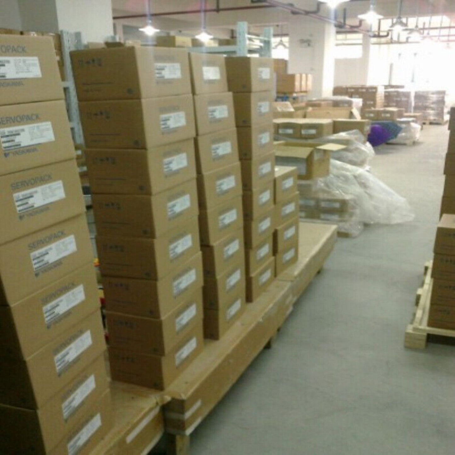 YASKAWA SERVOPACK boxes stacked in a warehouse, industrial automation components ready for expedited shipping.