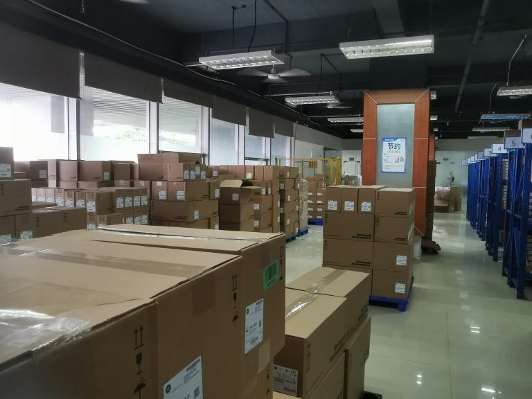 Warehouse stock of industrial automation parts, Schneider Electric HMIGX03502 in cardboard boxes, ready for shipment.