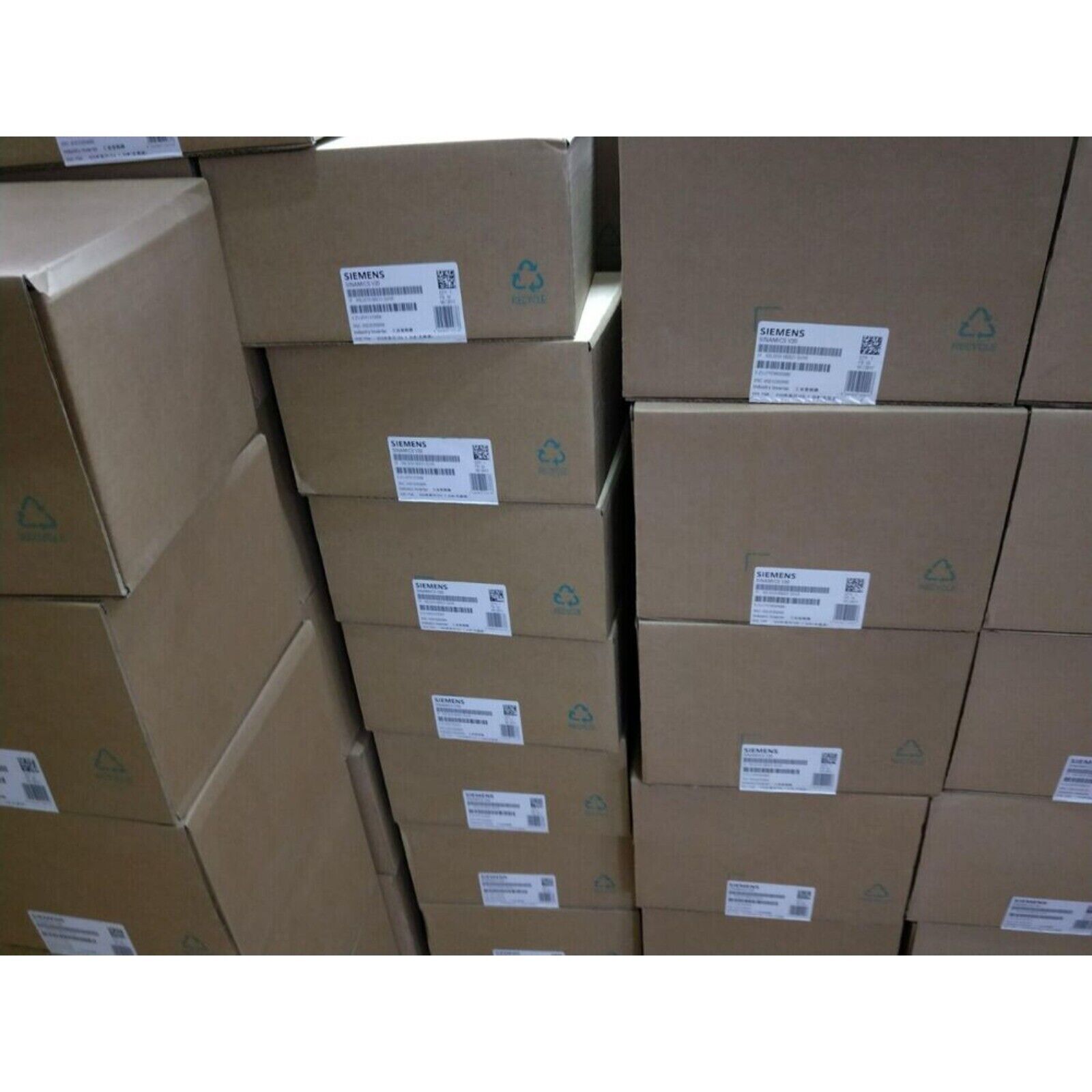 Stacked boxes of Siemens SINAMICS S120 drive system modules, new in stock, ready for shipping.