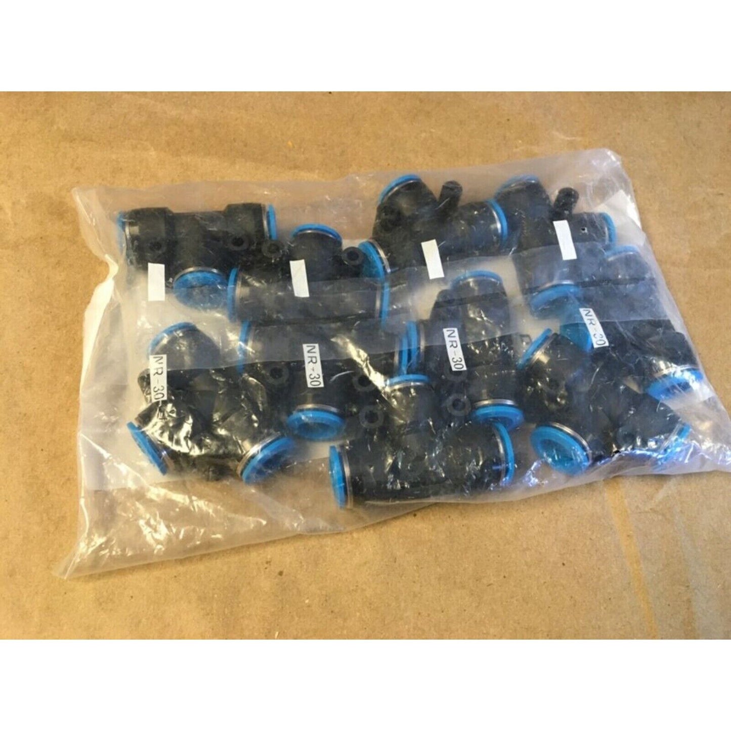 Festo QST-12 Push-In T-Connectors in plastic packaging, featuring black bodies and blue accents.
