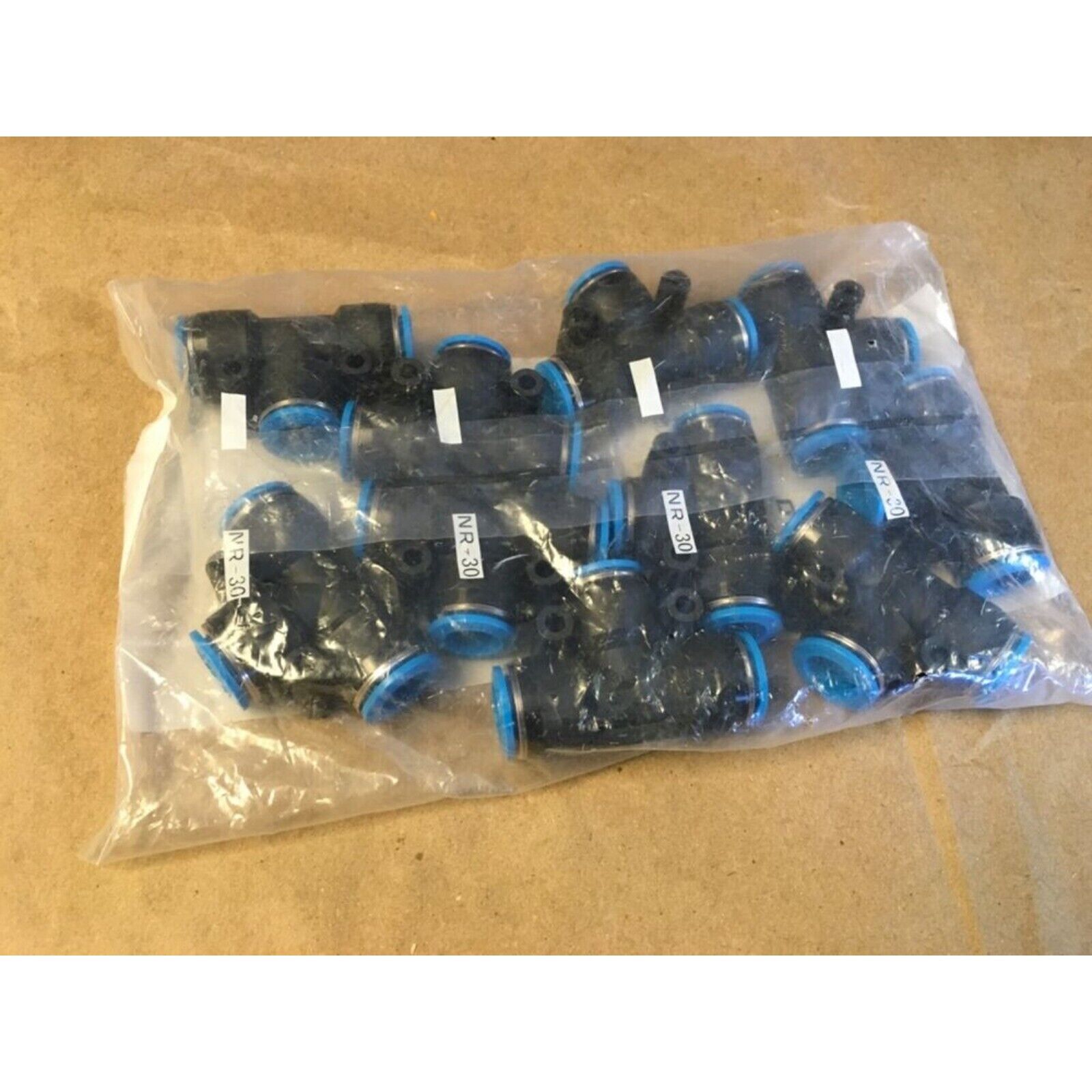 Festo QST-12 Push-In T-Connectors in plastic packaging, featuring black bodies and blue accents.