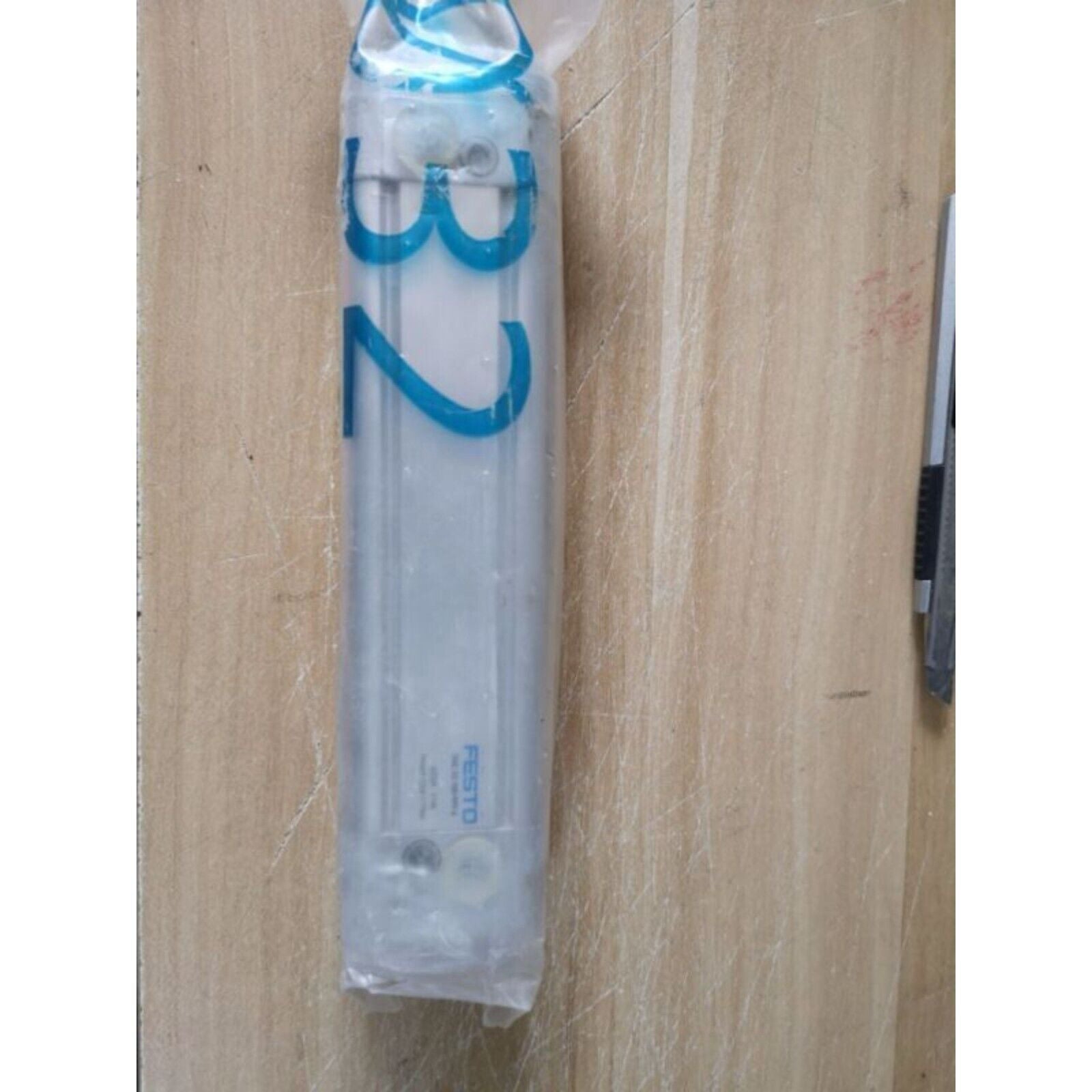 FESTO DNC-32-100-PPV-A cylinder in packaging with '32' and FESTO brand visible, industrial automation part.