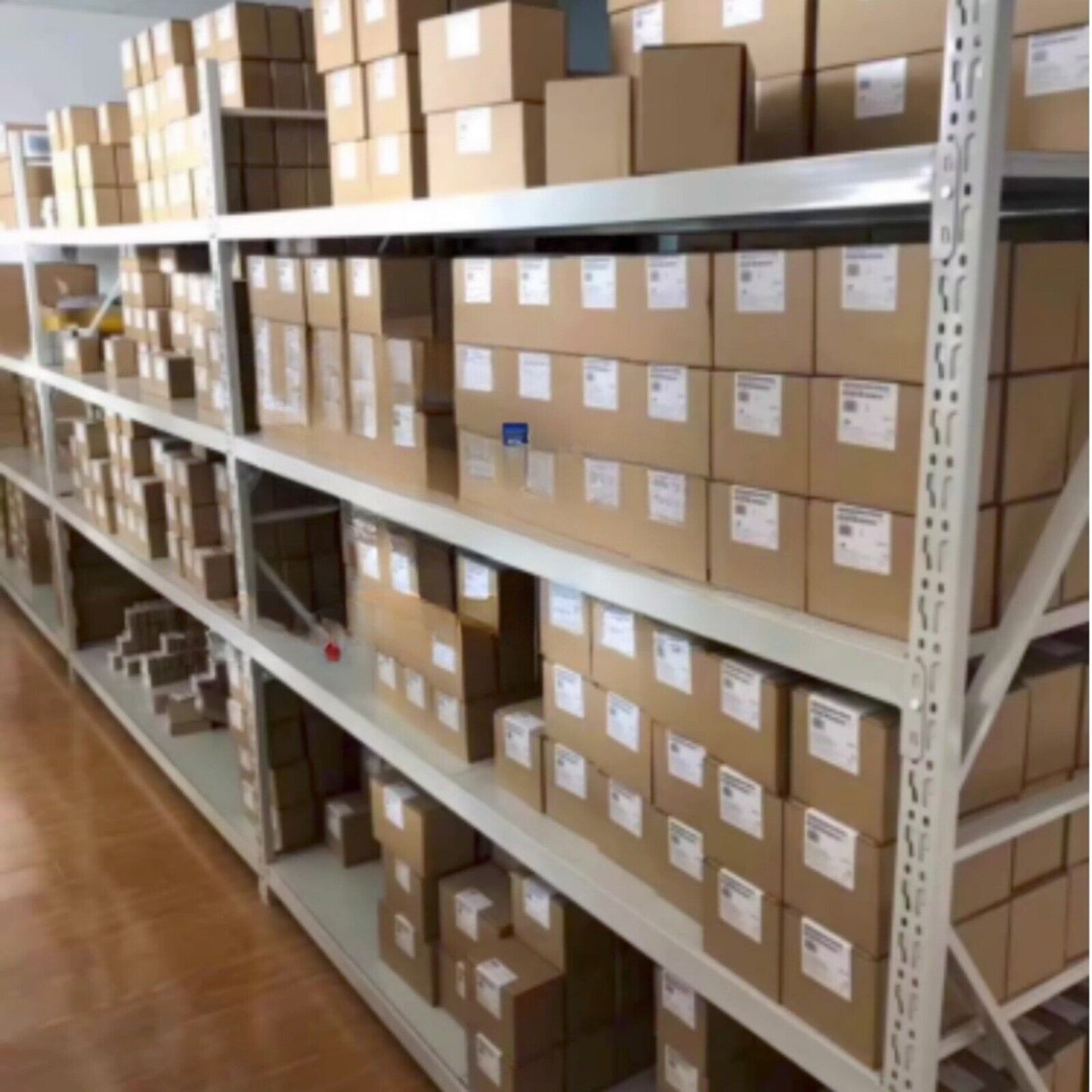 Industrial automation parts warehouse with Siemens parts, neatly organized on shelves.