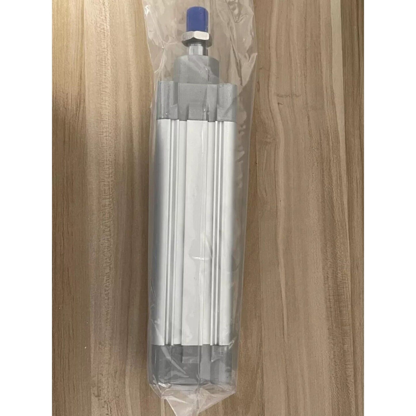 Festo DNC-50-125-PPV-A 163374 ISO cylinder in a clear plastic bag on a wooden surface.