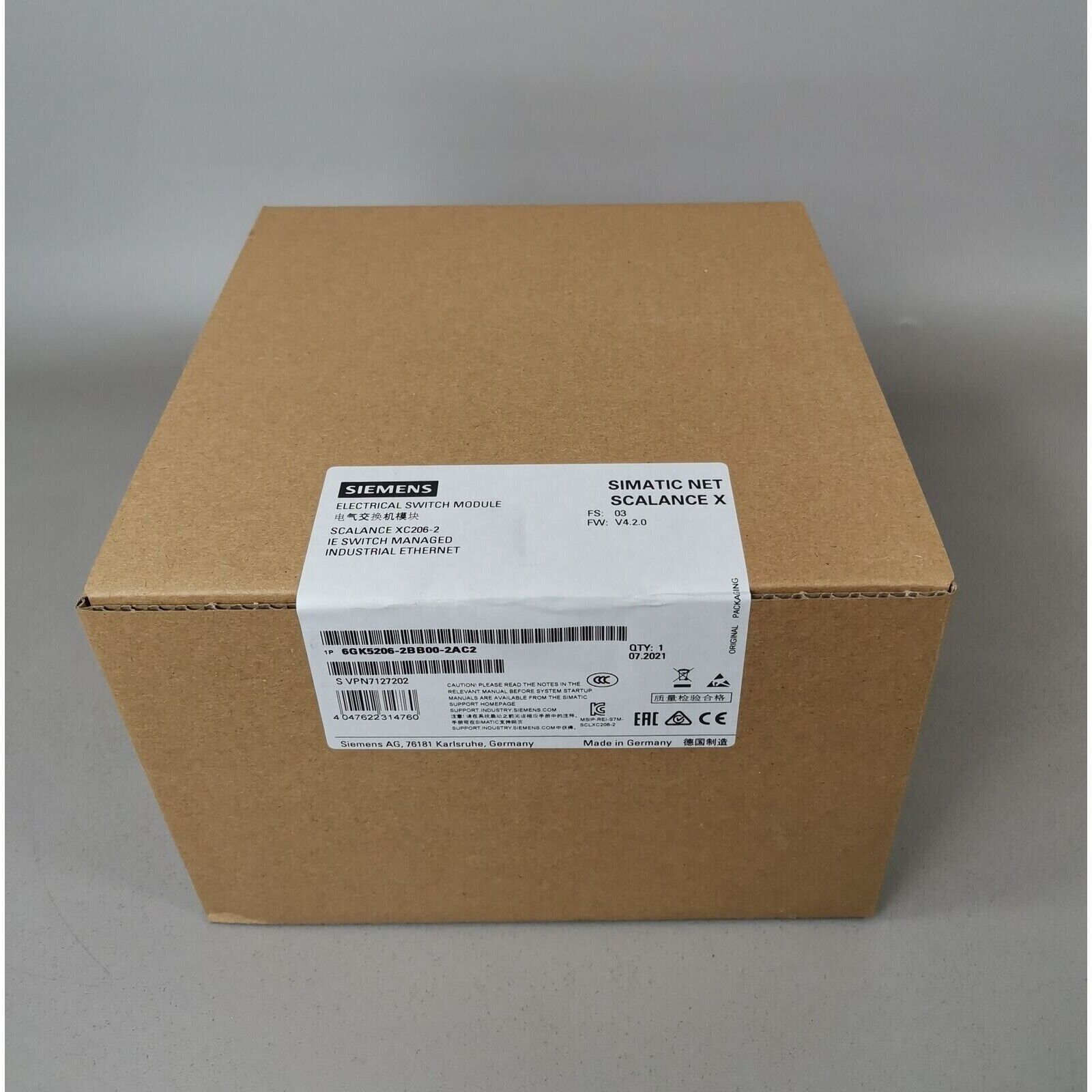 Siemens SCALANCE XC206-2 IE Switch box, industrial Ethernet switch, brown cardboard packaging, product details visible.