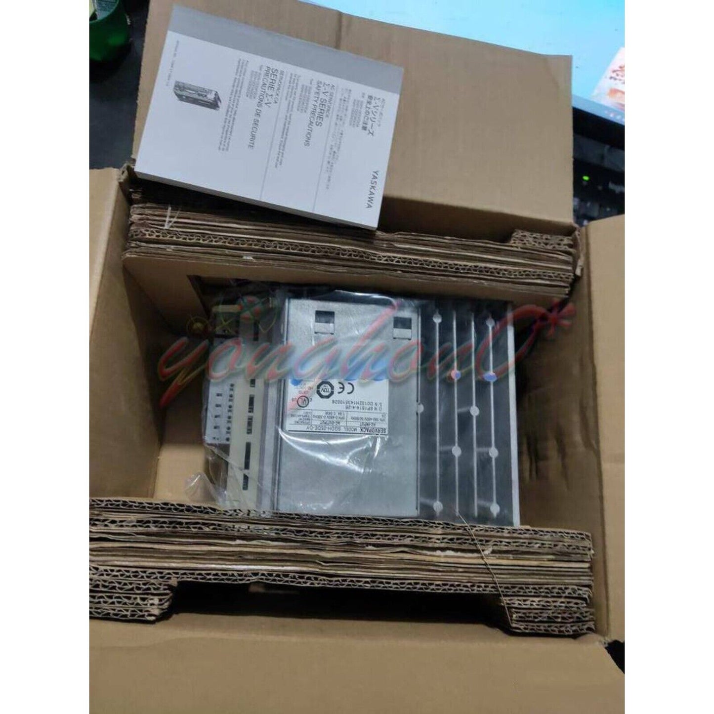 Yaskawa SGDH-05DE-OY servo drive in cardboard packaging with safety precaution documents