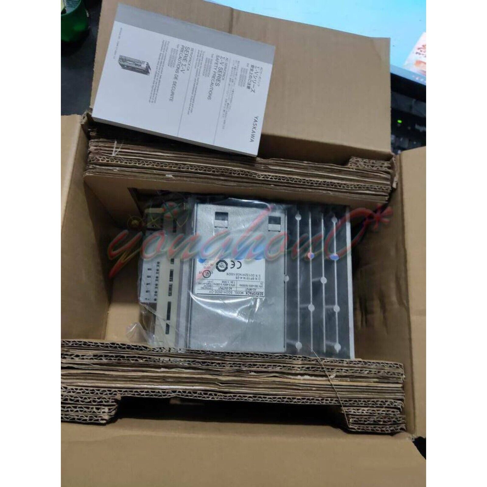 Yaskawa SGDH-05DE-OY servo drive in cardboard packaging with safety precaution documents