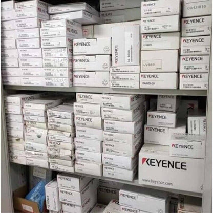 Keyence sensor product boxes stacked on shelf. Keyence industrial automation parts.