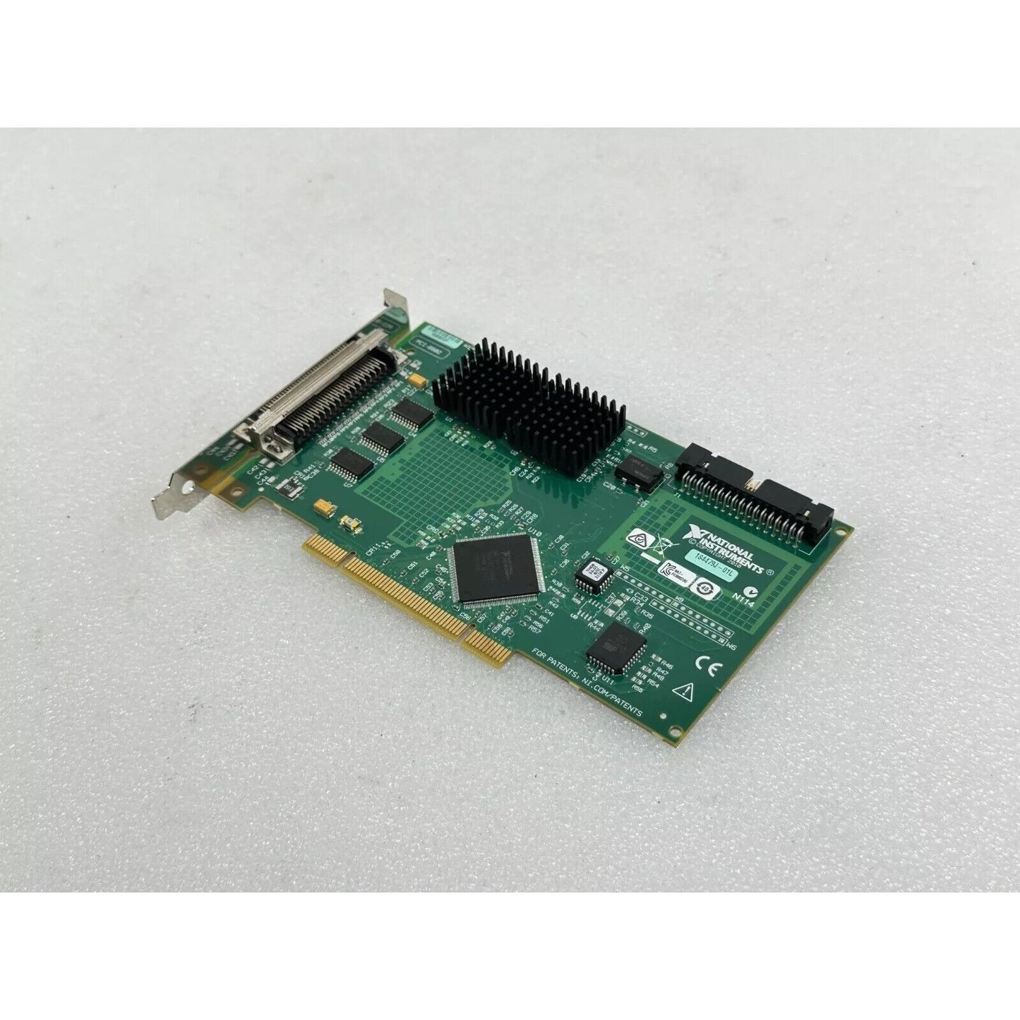 National Instruments PCI-6602 data acquisition card, green circuit board with black heat sink, for industrial automation.