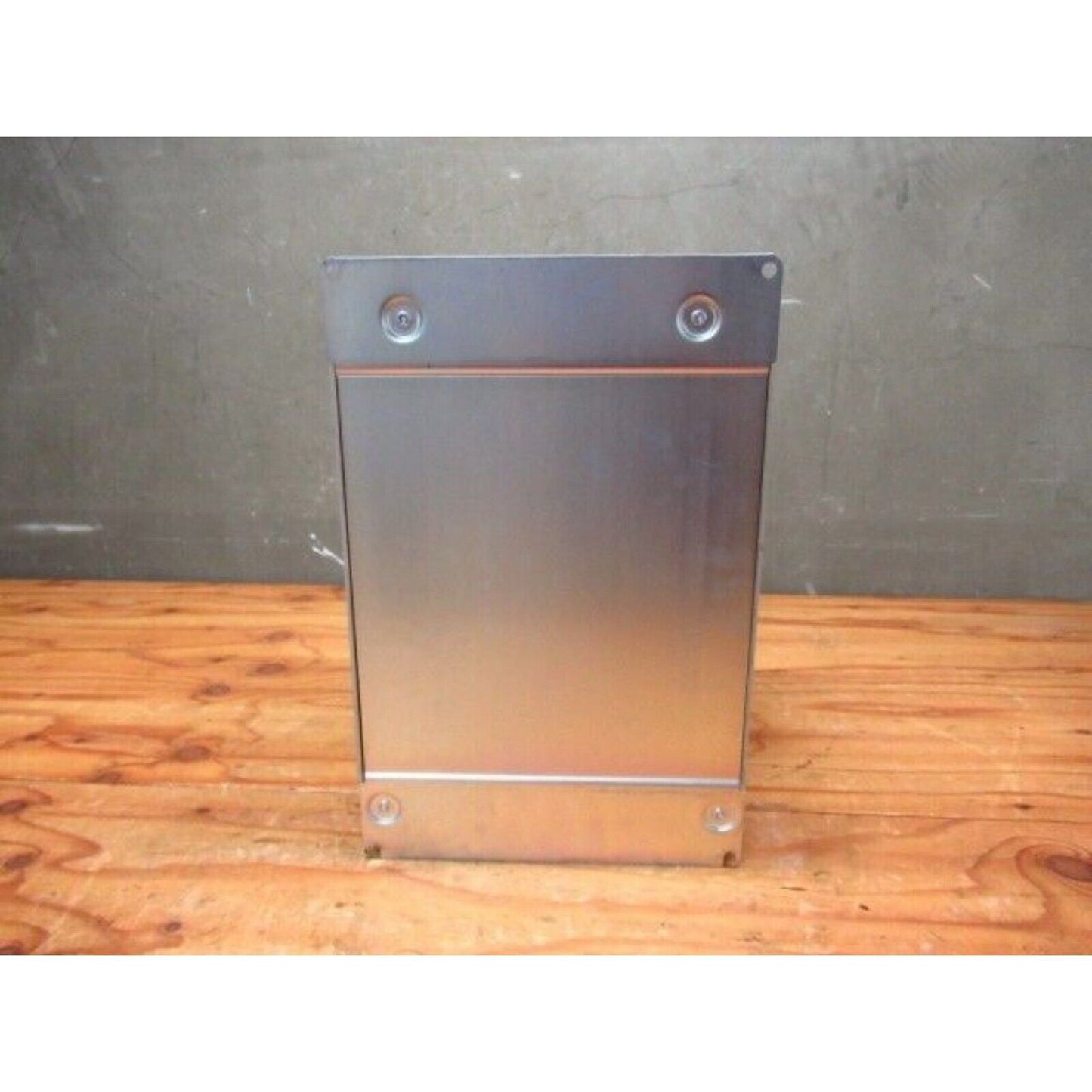 Silver YASKAWA G7 Inverter housing on wood surface, industrial automation part