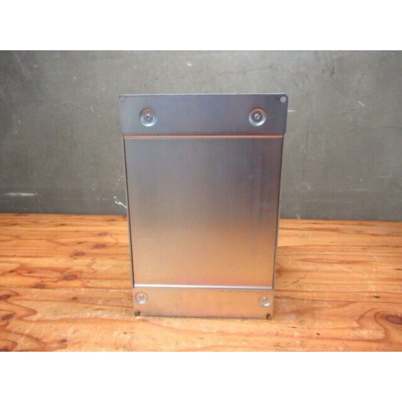 Silver YASKAWA G7 Inverter housing on wood surface, industrial automation part