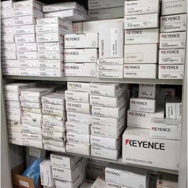 Keyence industrial automation parts inventory in white boxes on shelf, keyence.com.