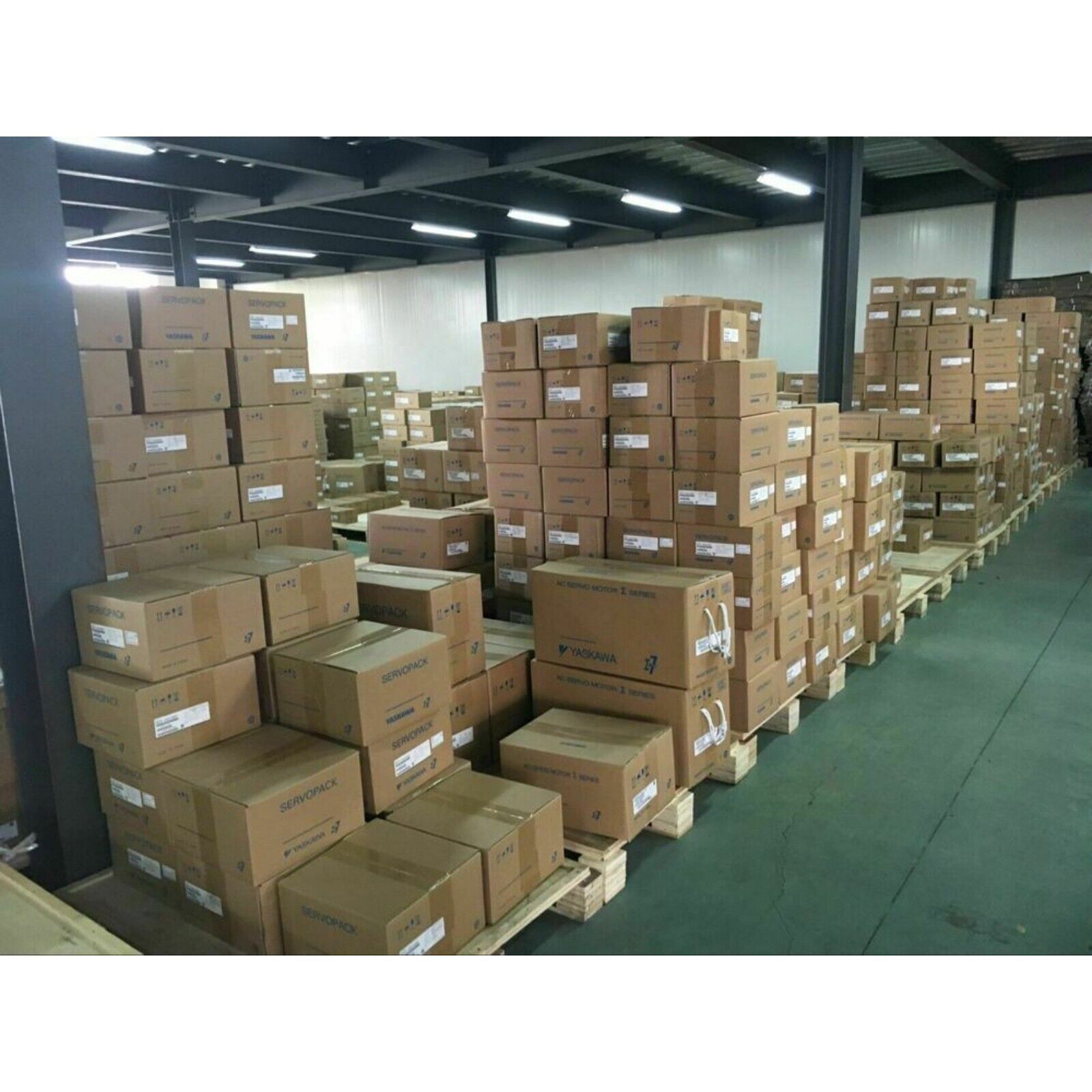 Warehouse stock of Yaskawa servo motors in boxes, labeled SERVOPACK, ready for shipment.