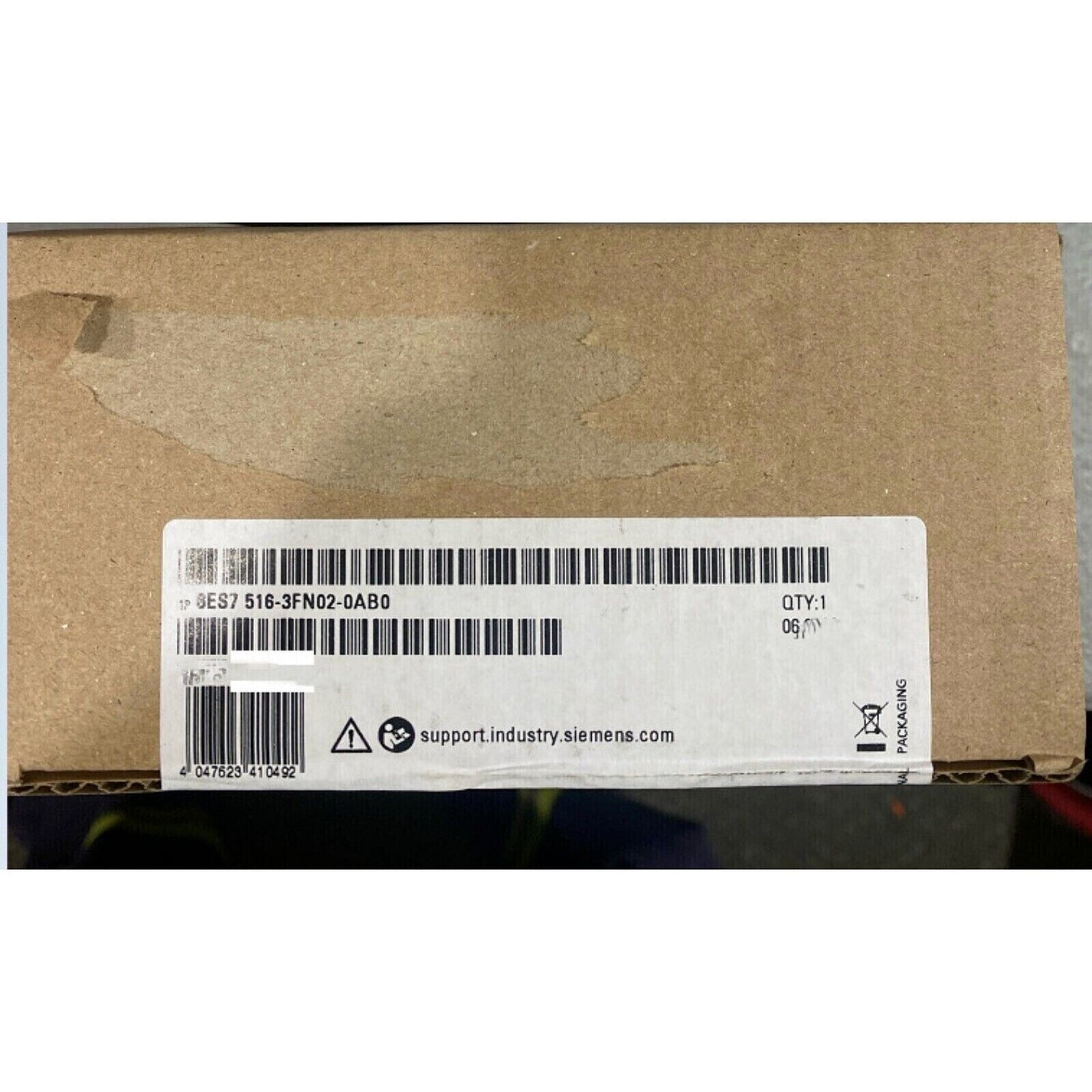 Siemens S7-1500 PLC in brown cardboard box, product code 6ES7516-3FN02-0AB0, with support website information.