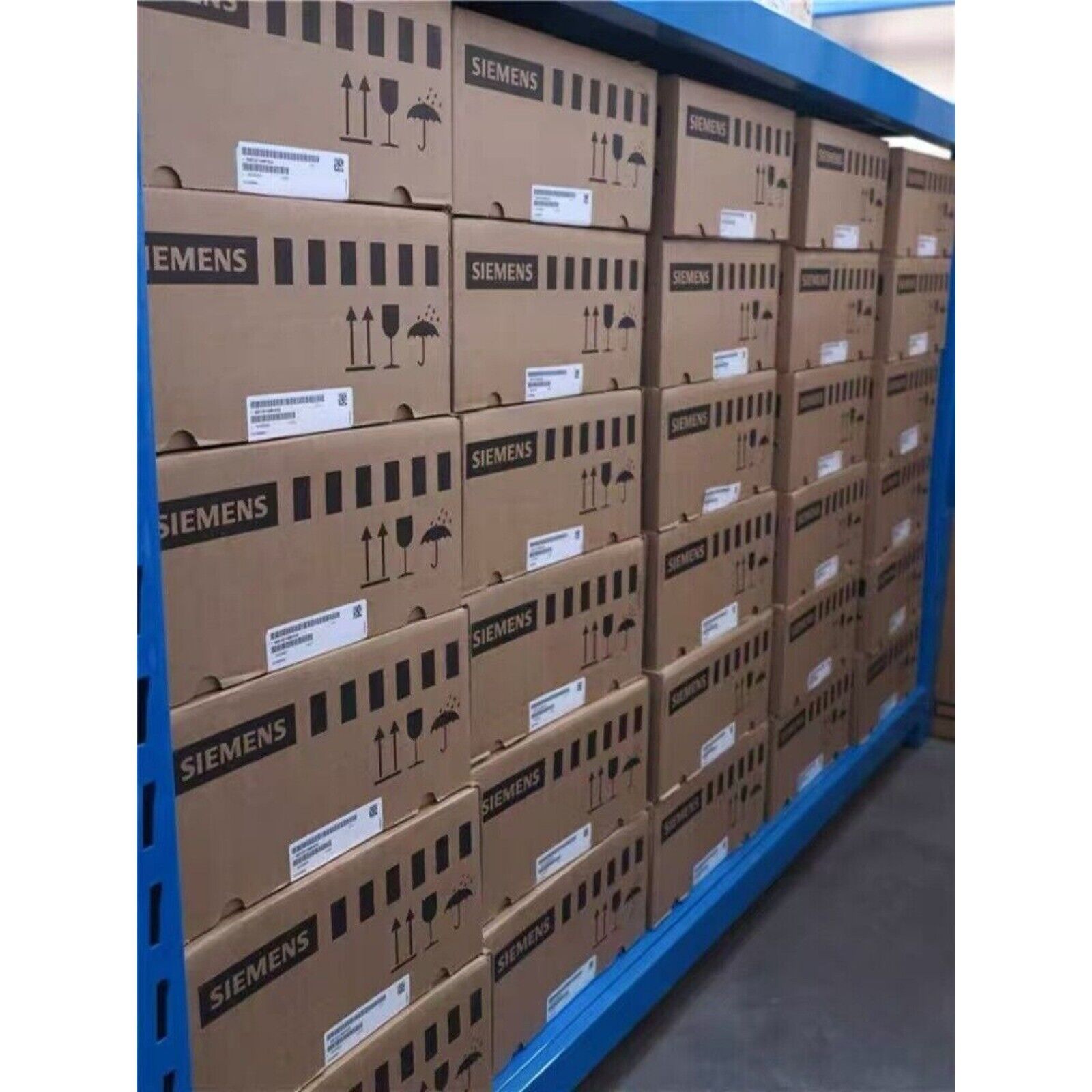 Siemens industrial automation parts boxes stacked on blue shelving. Packages with fragile labels.