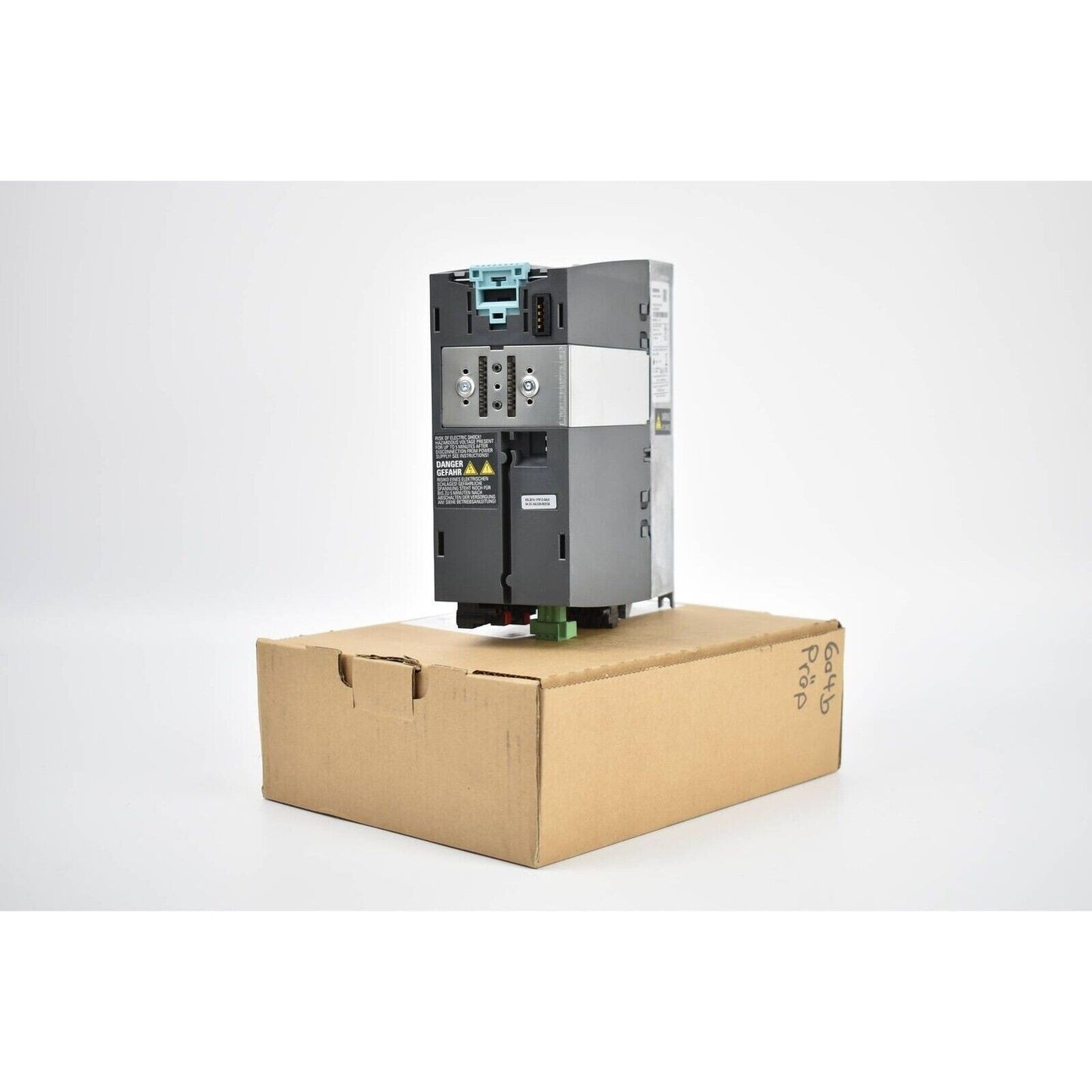 Siemens SINAMICS PM240-2 power module, model 6SL3210-1PB13-0AL0, industrial automation part in box, danger sign visible.