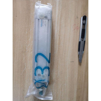 FESTO DNC-32-100-PPV-A actuator, industrial pneumatic cylinder, packaged with cutter on wood surface