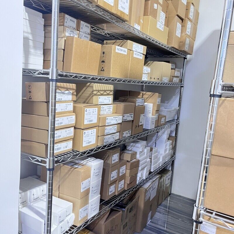 Warehouse shelves stocked with PLC modules and automation parts, ready for shipping, Factory Sealed.