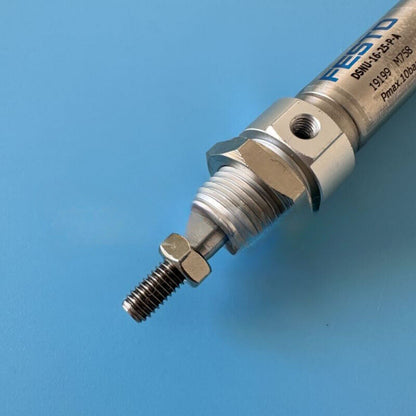 Festo DSNU-16-25-P-A Pneumatic Cylinder. Industrial automation component on a blue background.