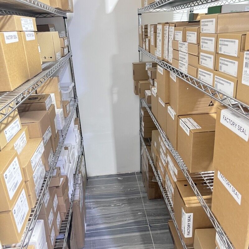 Warehouse shelves stocked with Allen-Bradley industrial automation parts, some labeled Factory Seal.